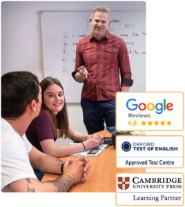Un profesor sonriente imparte curso de inglés para preparar examen Cambridge en Madrid. El texto de encima indica 4.8 de 5 estrellas en Google por parte de estudiantes satisfechos, y que somos centro preparador oficial para los exámenes de Cambridge y Oxford.