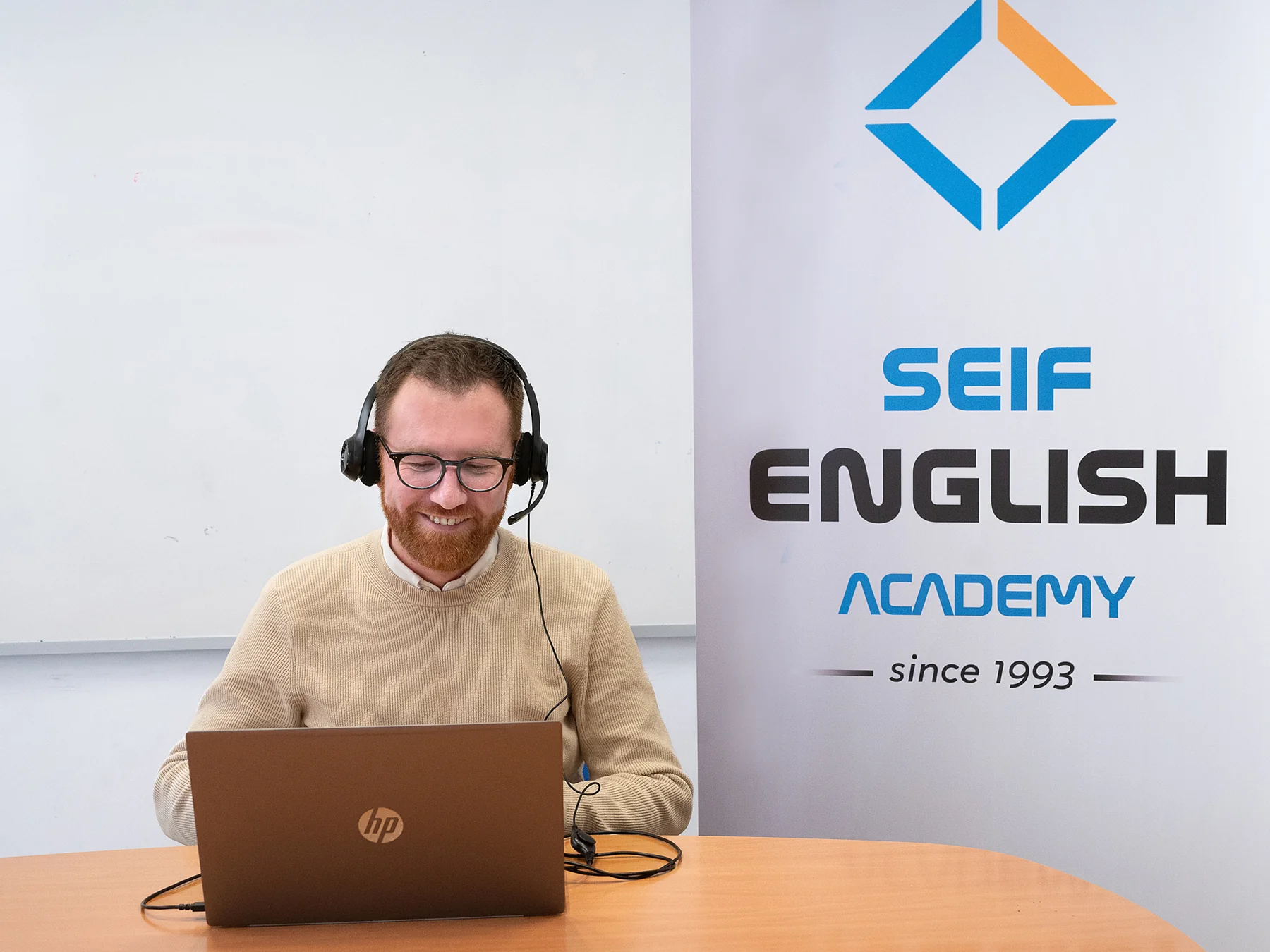 Detalle de una persona con auriculares junto a su portátil en Seif