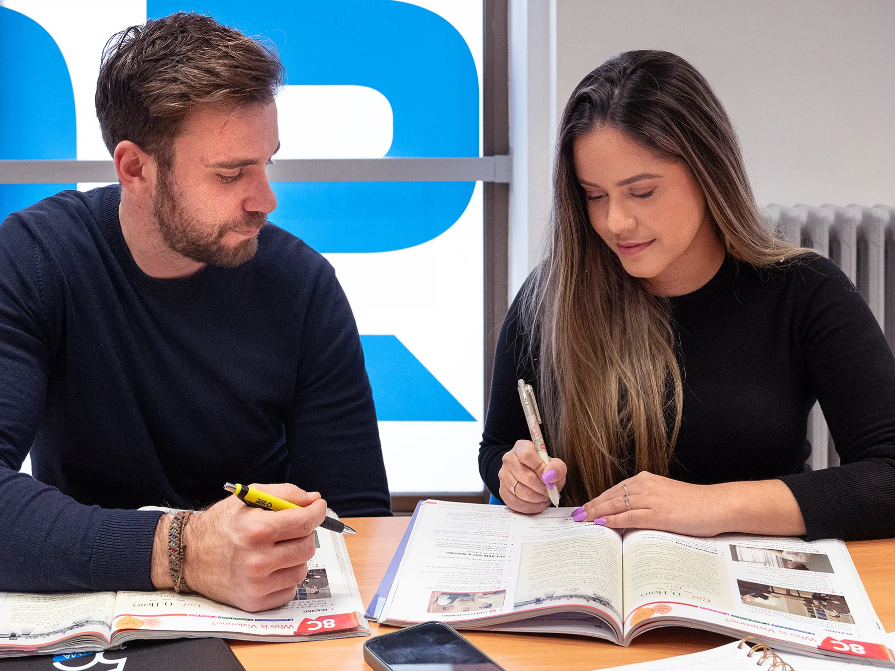 Dos personas trabajando con sus libros en Seif